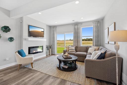 This fantastic living room provides a gathering space for friends and family. There is a convenient walk-out to the backyard and a lovely electric fireplace. Photo of model home, colors and finishes will vary.