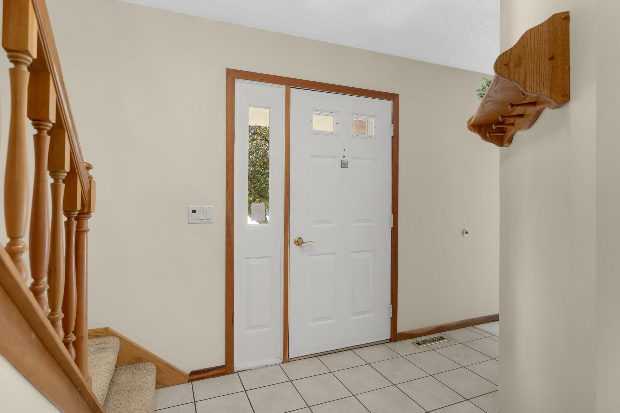 Welcoming entry w/ tiled flooring, natural woodwork, and an open flow into the main living areas.