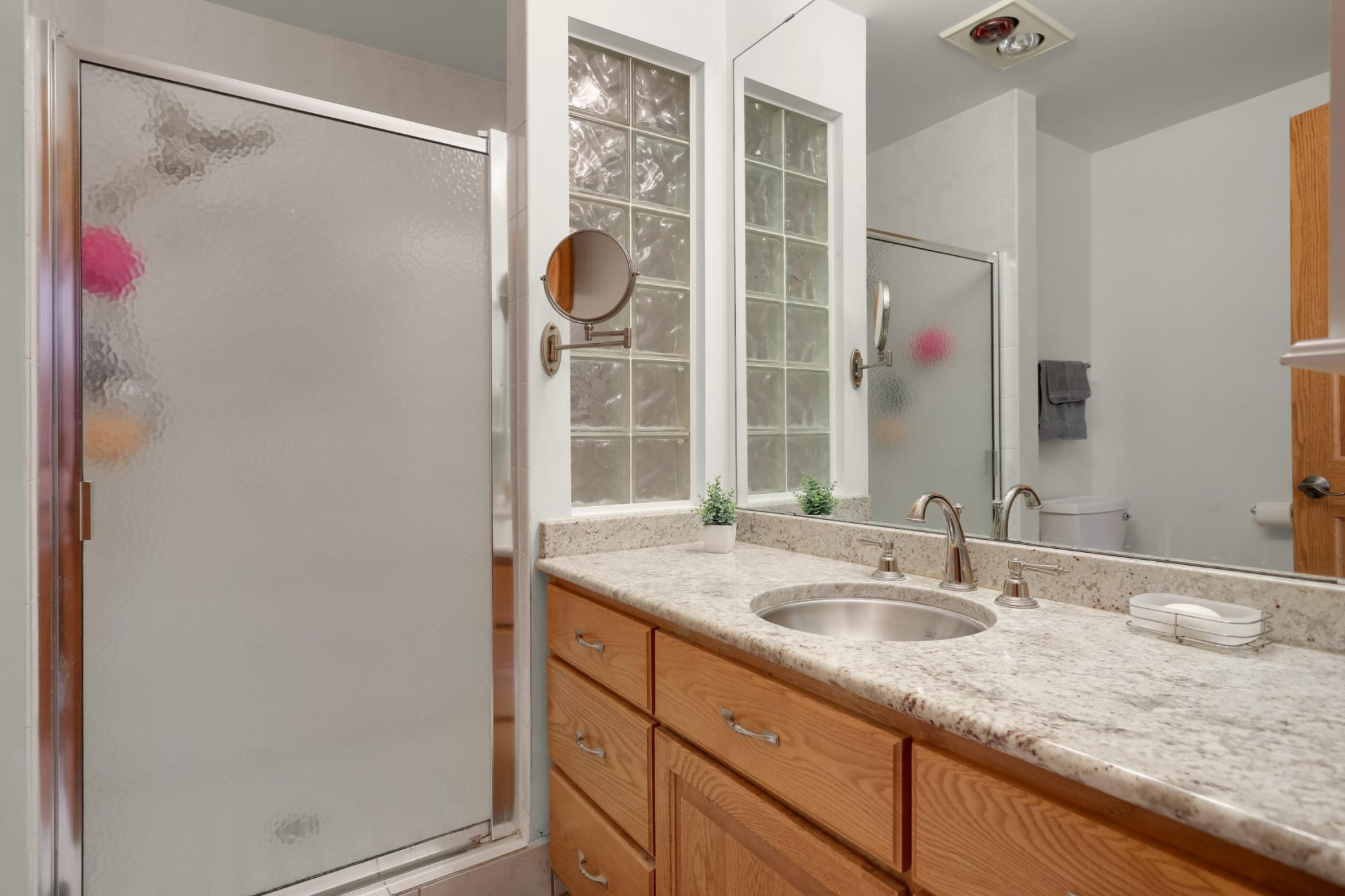 Private 3/4 bath w/ granite countertop, stainless steel sink, and walk-in shower.
