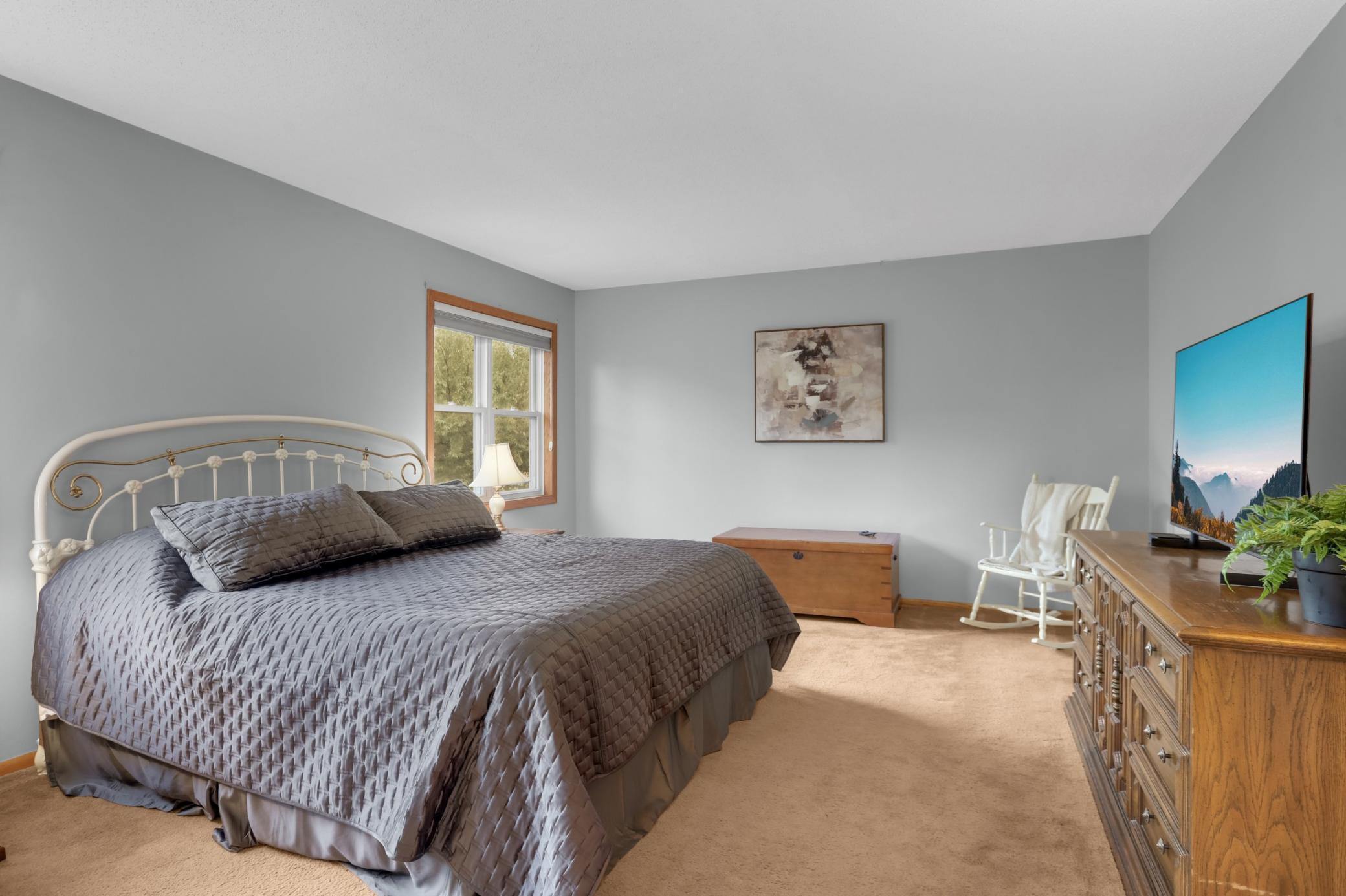 Spacious primary suite on upper level w/ walk-in closet.