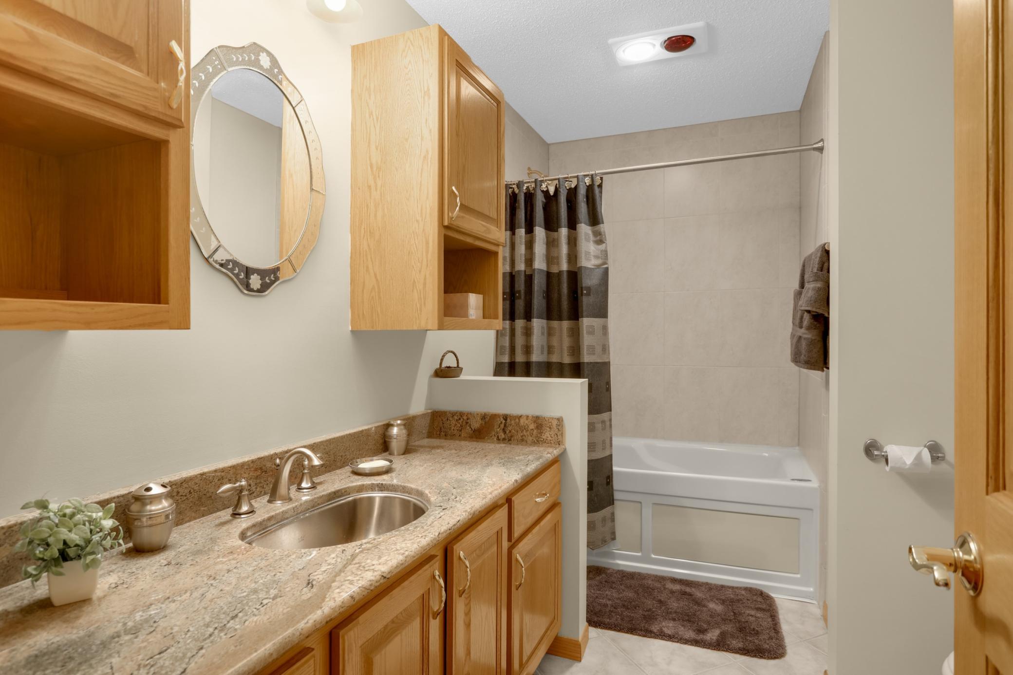 Upper level full bath w/ granite countertop, stainless steel sink, and jetted tub.