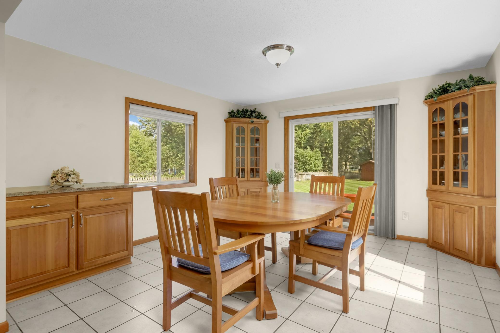 Sun-filled formal dining room w/ custom cherry built-ins and deck access overlooking the fenced backyard.