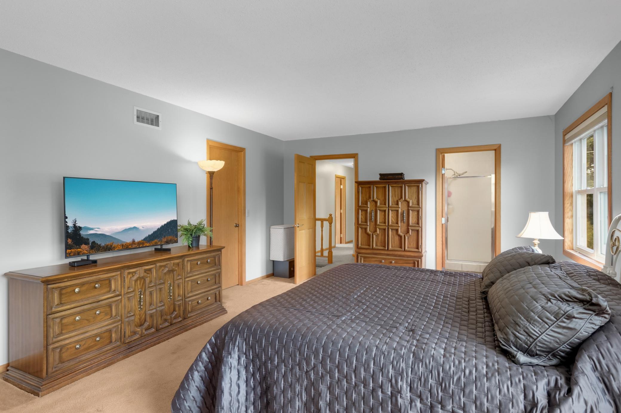 Spacious primary suite on upper level w/ walk-in closet.