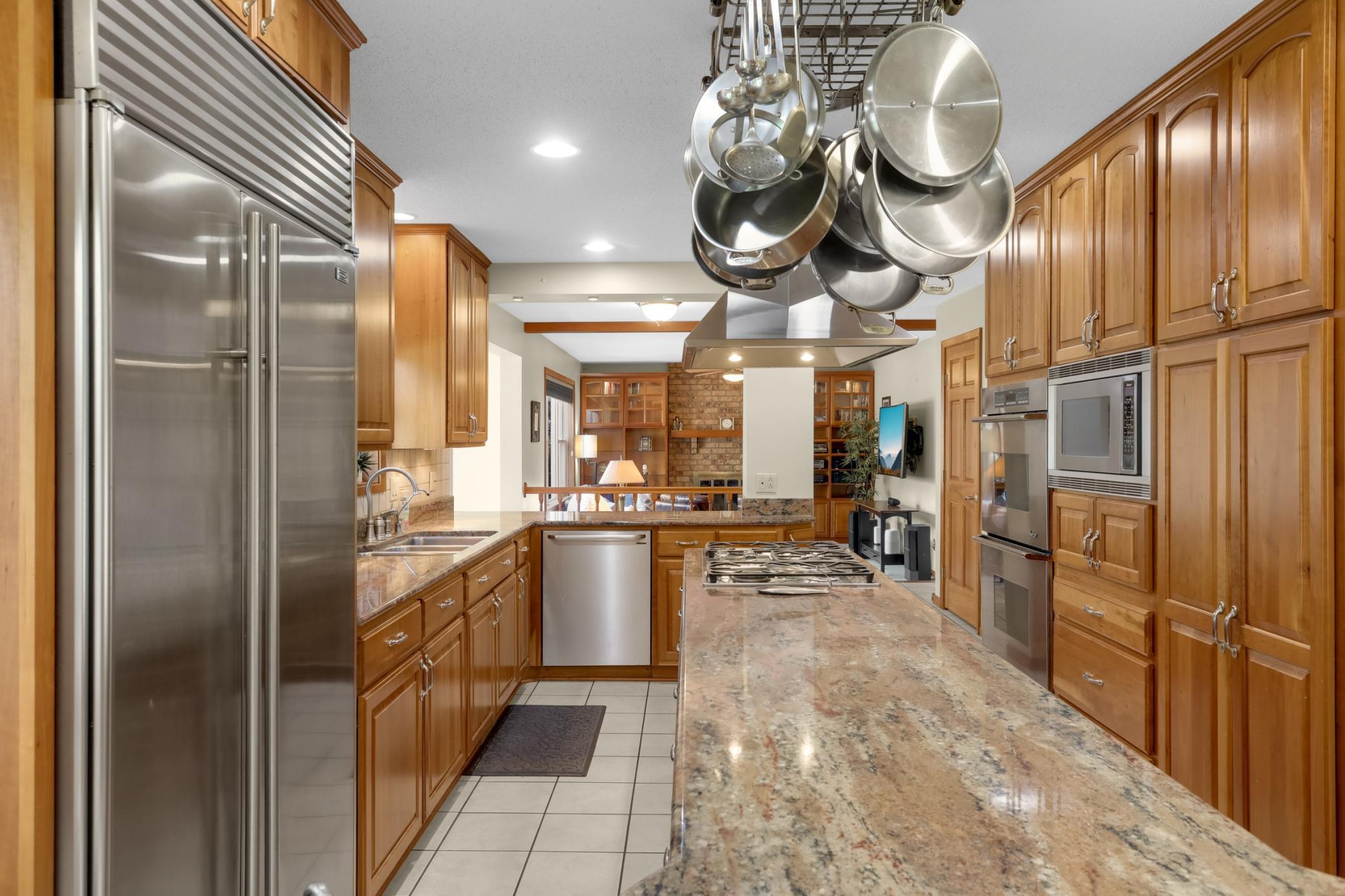 Gourmet Kitchen w/ large center island, granite counters, custom cherry cabinetry, stainless steel appliances and hood.