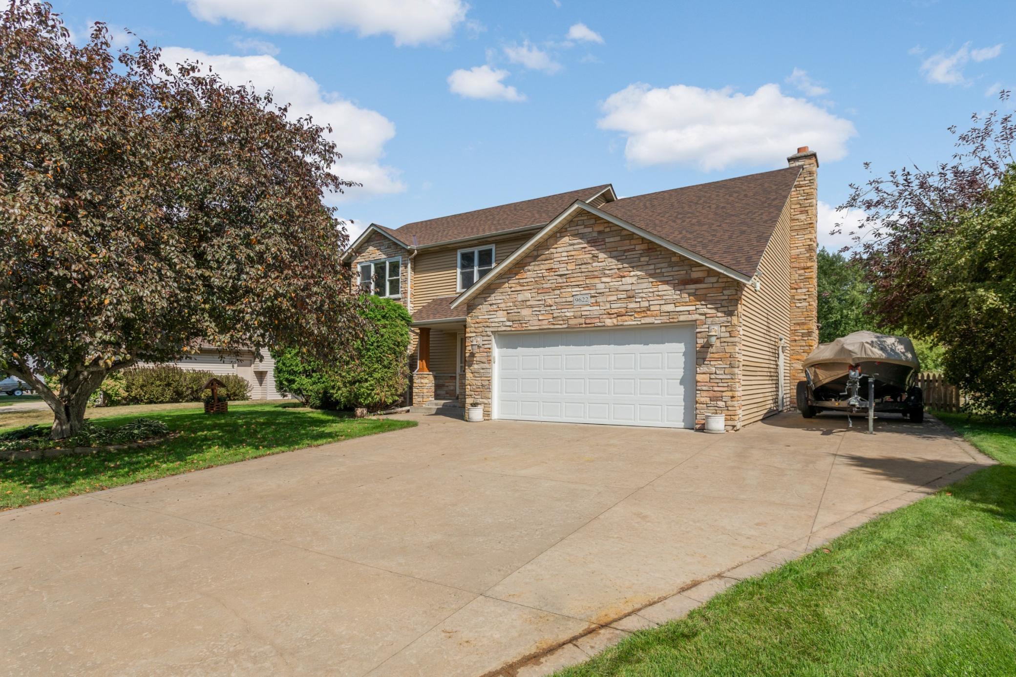 Set on a quiet, established street, this welcoming two-story has stone accents, a covered front entry and expansive stamped concrete driveway.