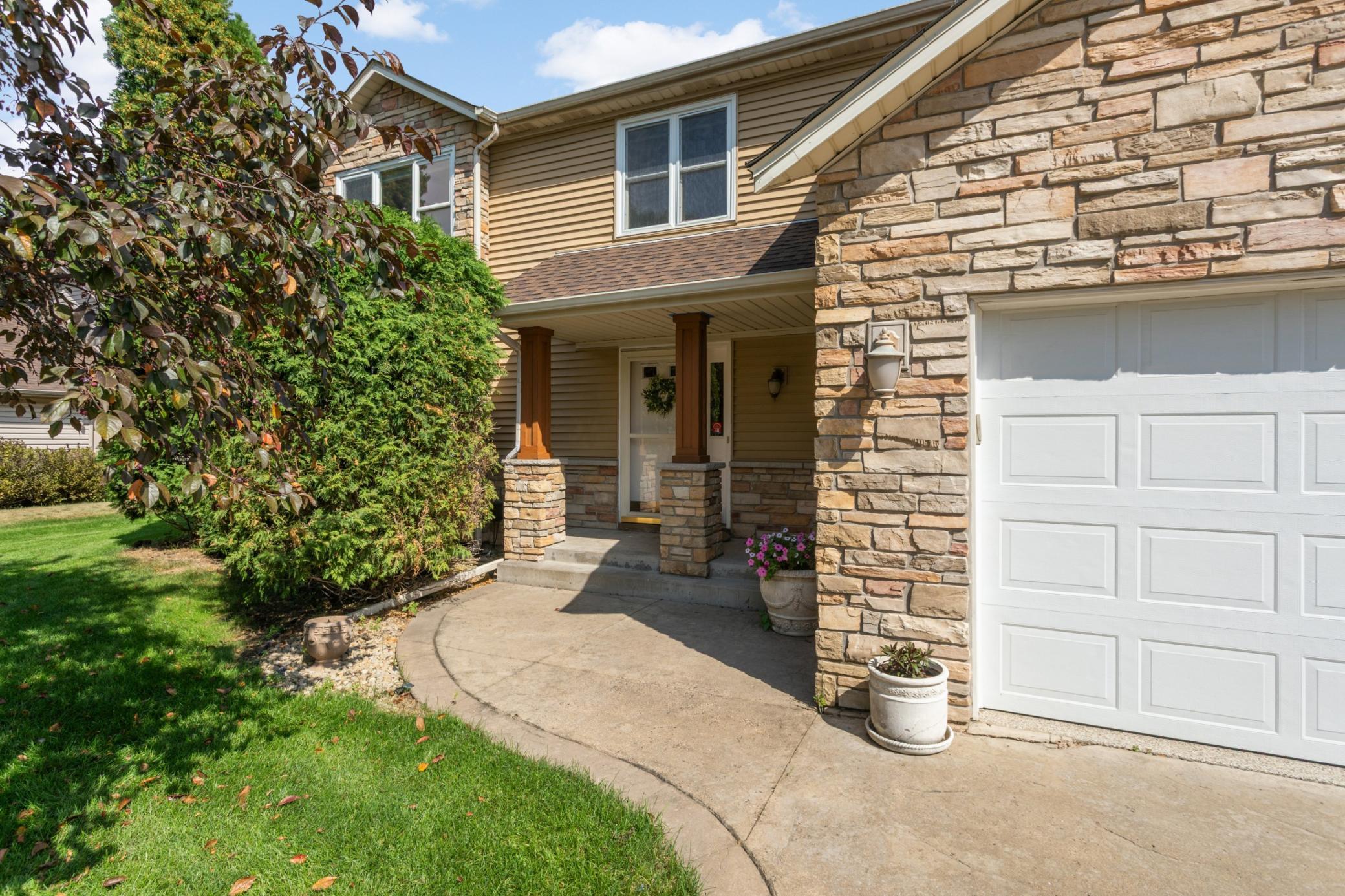 Set on a quiet, established street, this welcoming two-story has stone accents, a covered front entry and expansive stamped concrete driveway.