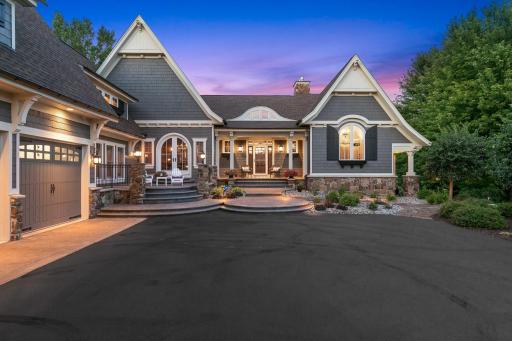 A grand front elevation highlighted by timeless craftmanship, stone accents, and a welcoming covered porch.
