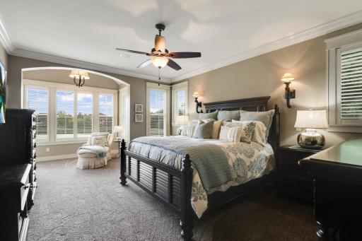 Luxurious primary suite with private sitting area and tray ceiling.