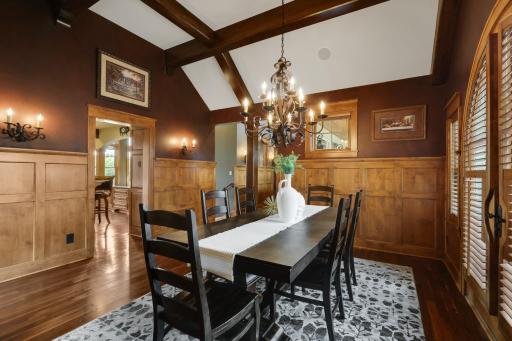 Refined formal dining room with custom knotty alder millwork, a dramatic coffered ceiling, and French doors to the outdoor patio.