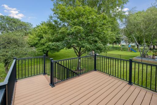 Spacious, like new, composite deckk steps down to pretty backyard