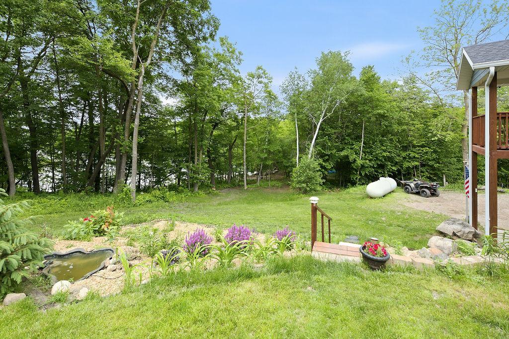 Yard offers landscaping, garden beds, pond & lots of space to spread out