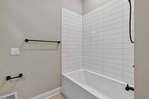 Oversized tub features a ceramic tile surround