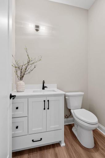 1/2 bathroom features enameled vanity with quartz top