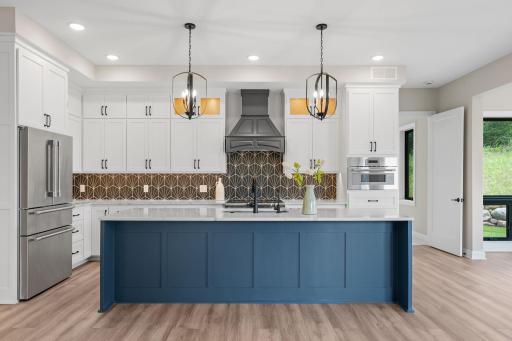 Kitchen features enameled cabinetry features flat panel and glass doors with interior accent lighting, roll-out storage, full height pantry, under cabinet lighting and an oversized âEat-Inâ center island