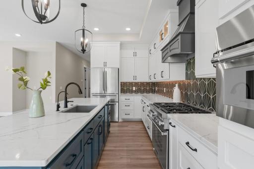 Quartz countertops with composite sink and decorative tile backsplash