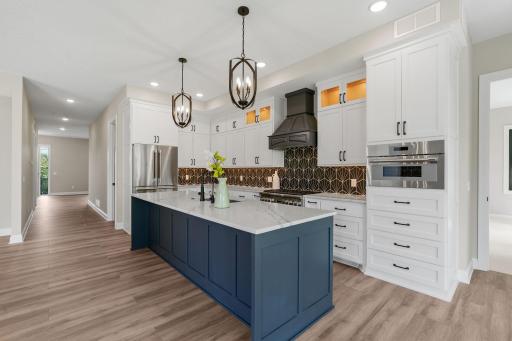 High-end Thermedor stainless steel appliances include a french door refrigerator, 36â gas cooktop with cabinet paneled hood, wall oven and cabinet paneled dishwasher