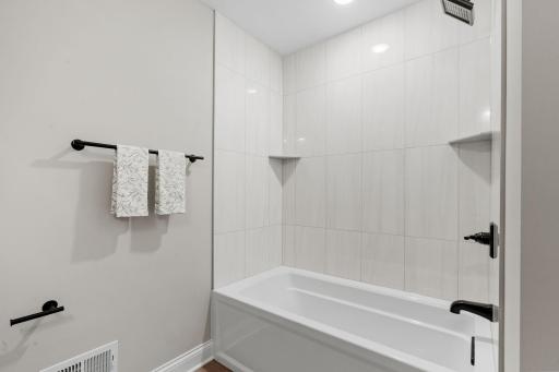 Oversized tub features a ceramic tile surround