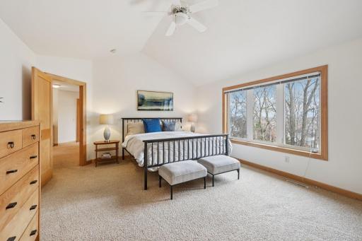 Primary suite with vaulted ceilings and large windows to backyard