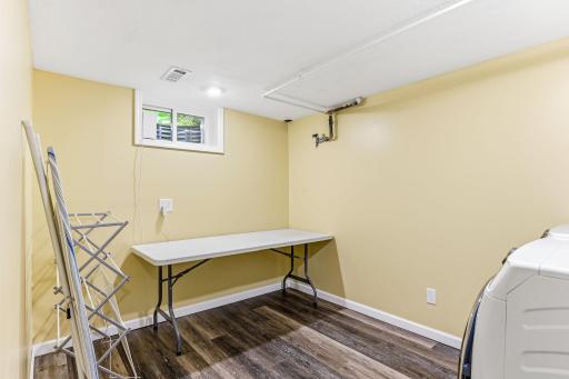 Lower-level laundry room finished with clean, durable laminate flooring—offering a practical, easy-maintenance surface for everyday laundry tasks.