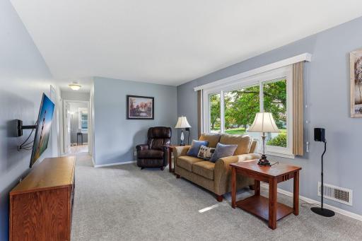 Bright, welcoming living room anchored by a large picture window that fills the space with natural light.