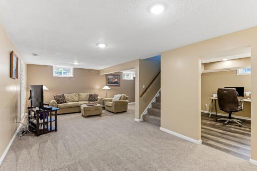 Spacious lower level featuring a comfortable family room, a dedicated office area, a fourth bedroom, and a second bath—an ideal setup for flexible living, guests, or work-from-home needs.
