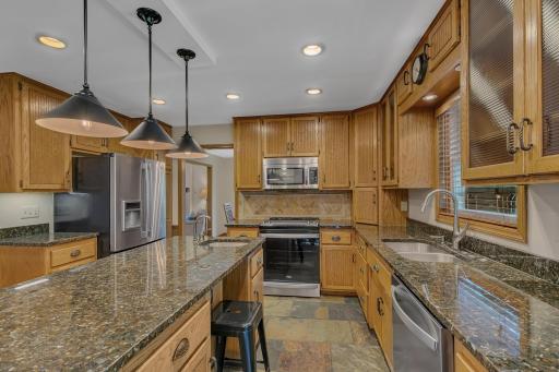 Stainless steel appliances, recessed lighting and tiled flooring.