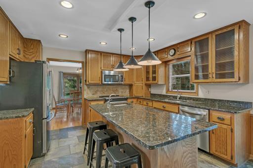 A center island complete with a sink, electrical outlet, generous cabinetry, and additional drawer storage.