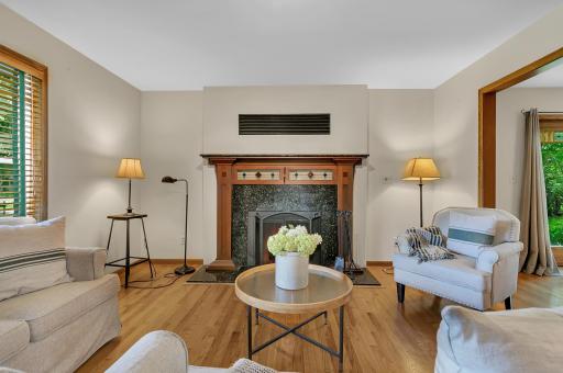 The living room is highlighted by a wood-burning fireplace with a stunning granite surround, decorative wood pillars, and a granite hearth.