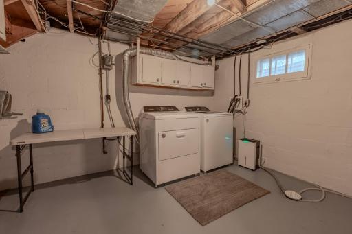 Laundry room in basement is comfortable & spacious storage and utility room too