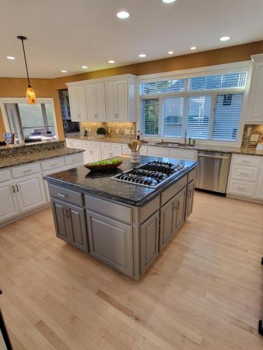 Large center island with gas cooktop and granite surface