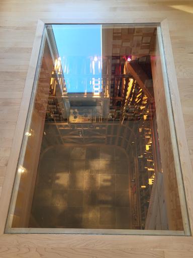 Dramatic see-thru floor looks down into the wine room