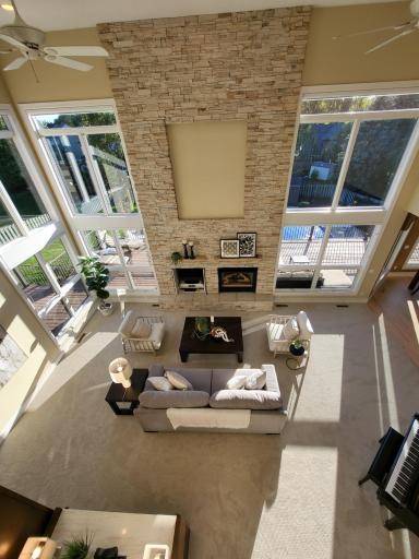 Two story family with floor to ceiling windows and spectacular stone fireplace