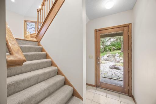 Landing between the kitchen and lower level. Door leads to the private patio and backyard.