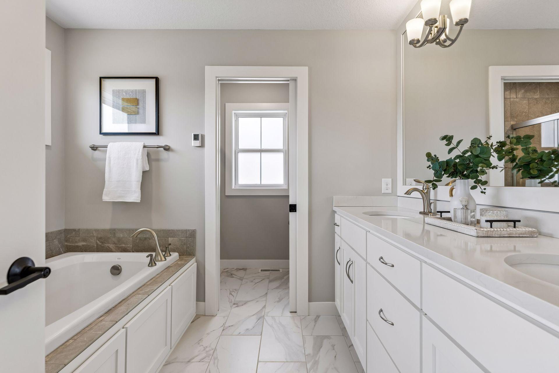 Primary bath with double sinks, soaking tub, & shower
