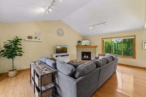 Two story vaulted ML living room with maple hardwood floors and cozy gas fireplace.