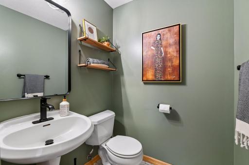 Half bath on main with new tile floors, lighting and mirror.