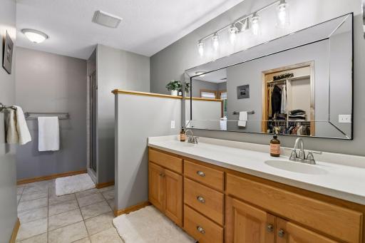 Primary bath with tile floors, dual vanity, walk in closet, new mirror updated lights and separate tub/shower.