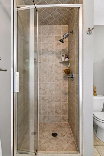 Walk in tile surround shower in primary bathroom.