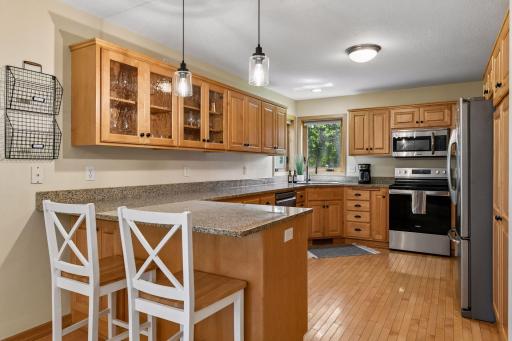 Beautiful kitchen with Maple custom cabinetry, granite counters, new lighting, new range 2024 and new dishwasher 2025.