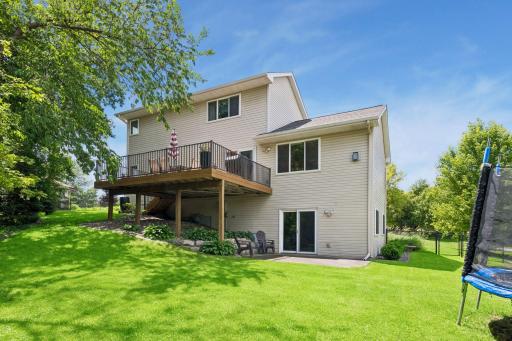 Back of home showing walkout, deck, lower patio space and fenced in yard.