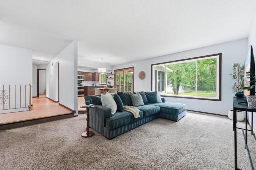 Comfortable living space filled with natural light and offering a warm, inviting space that flows to the dining area and sunroom.