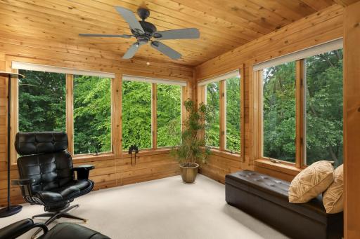 Sunroom surrounded by peaceful trees with views of Glen Lake in the winter.