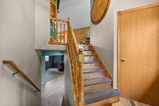 Split-level foyer with warm wood staircase and railing.