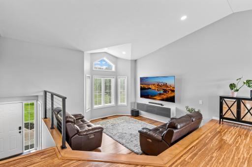 Open concept sunken living room with cathedral bay window