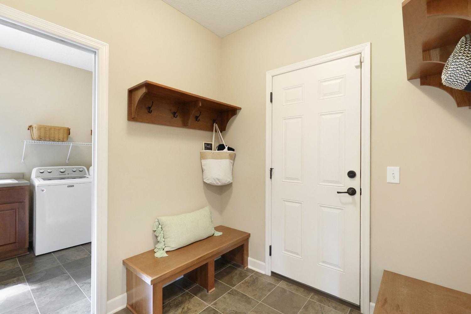 Convenient mudroom with built-in bench and direct garage access.