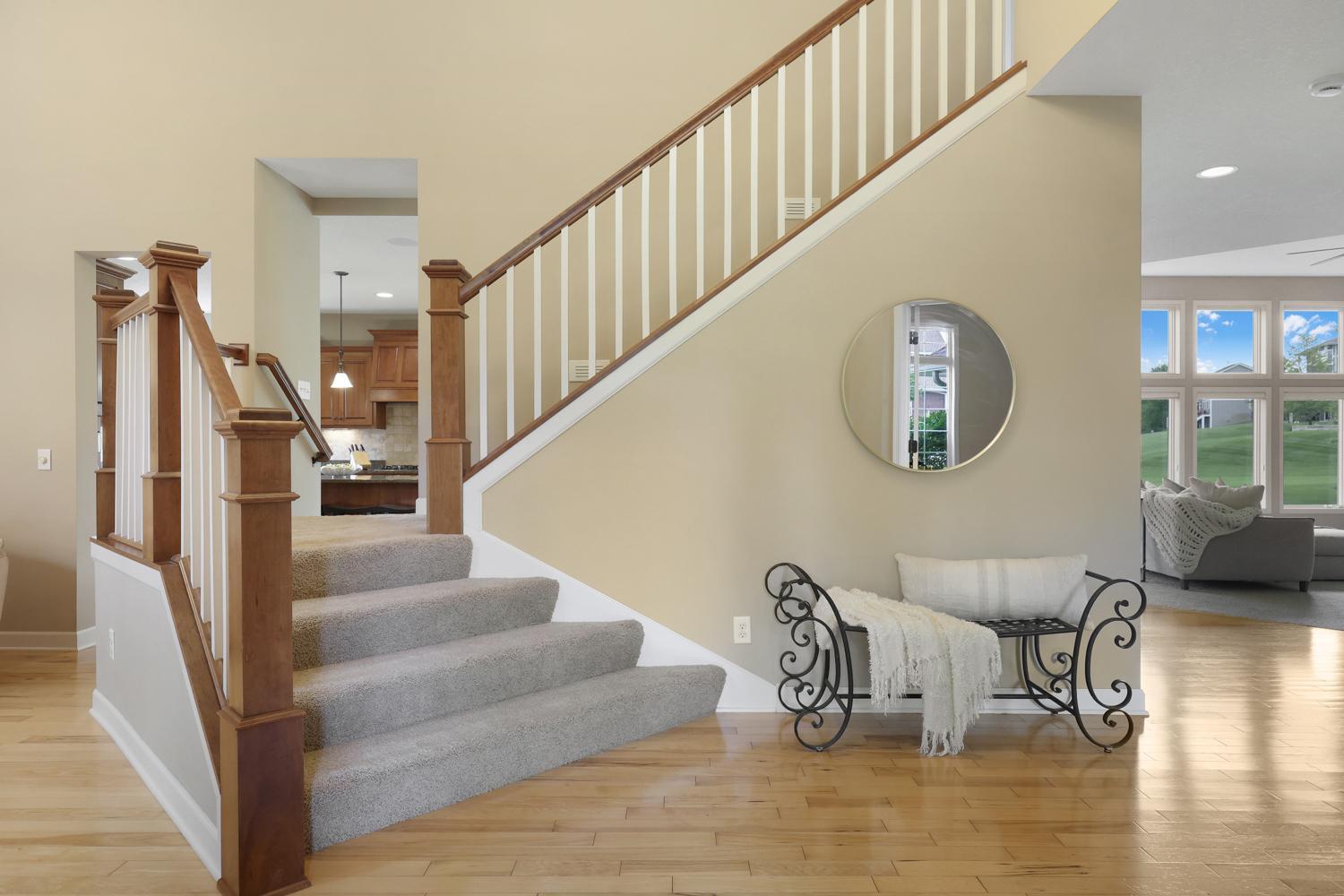 Grand two story with rich hardwood floors, custom millwork and an open staircase creating a warm first impression.
