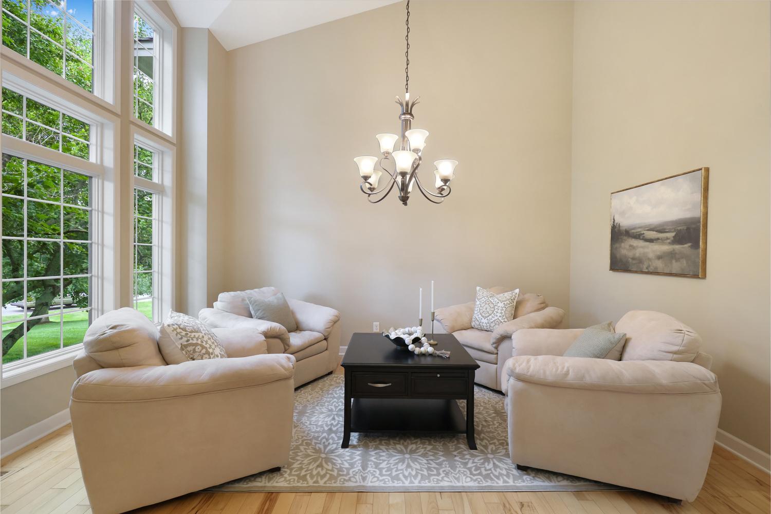 Elegant formal living room or dining room, featuring soaring ceilings, oversized windows and abundant natural light.