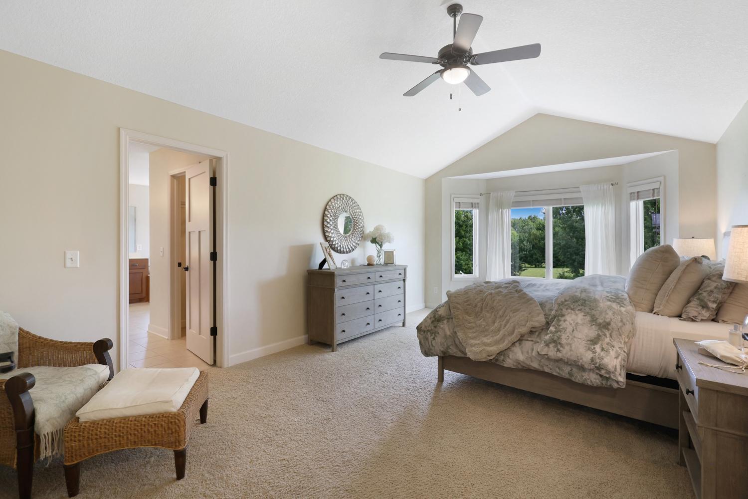 Spacious primary suite featuring a vaulted ceiling, abundant light, and a private ensuite bath.