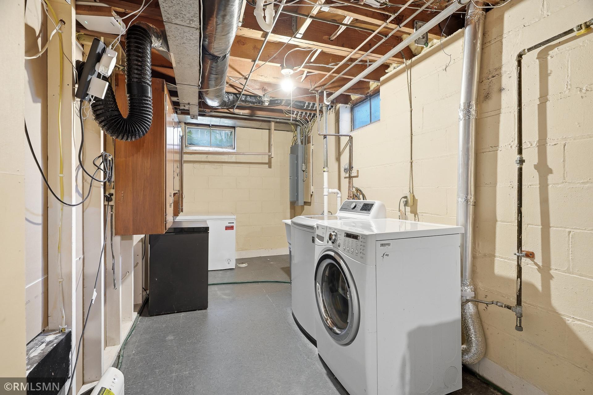 Clean spaces for a newer washer and dryer, along with two freezers.