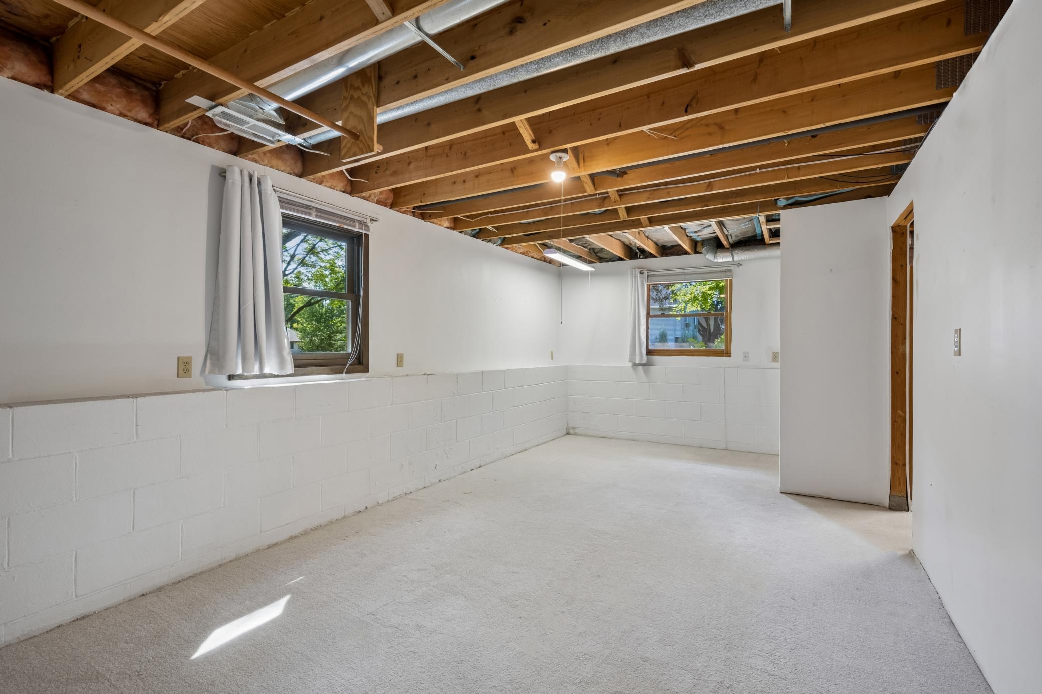 Lower-level recreation room or future fourth bedroom with new carpet, ready for your finishing touches.